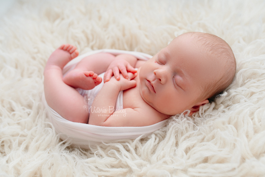 newborn on cream flokati rug