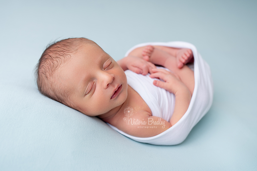 newborn baby on blue backdrop