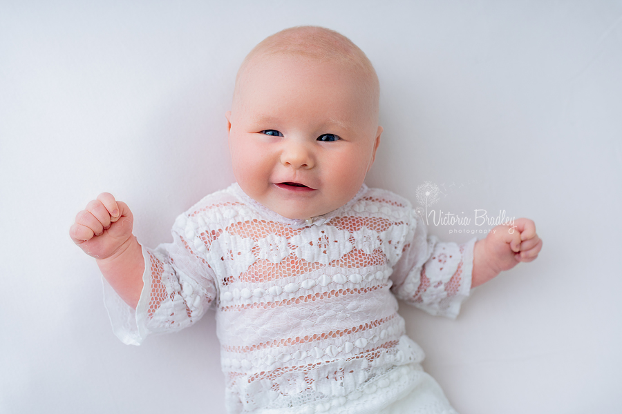 smiley newborn on white backdrop