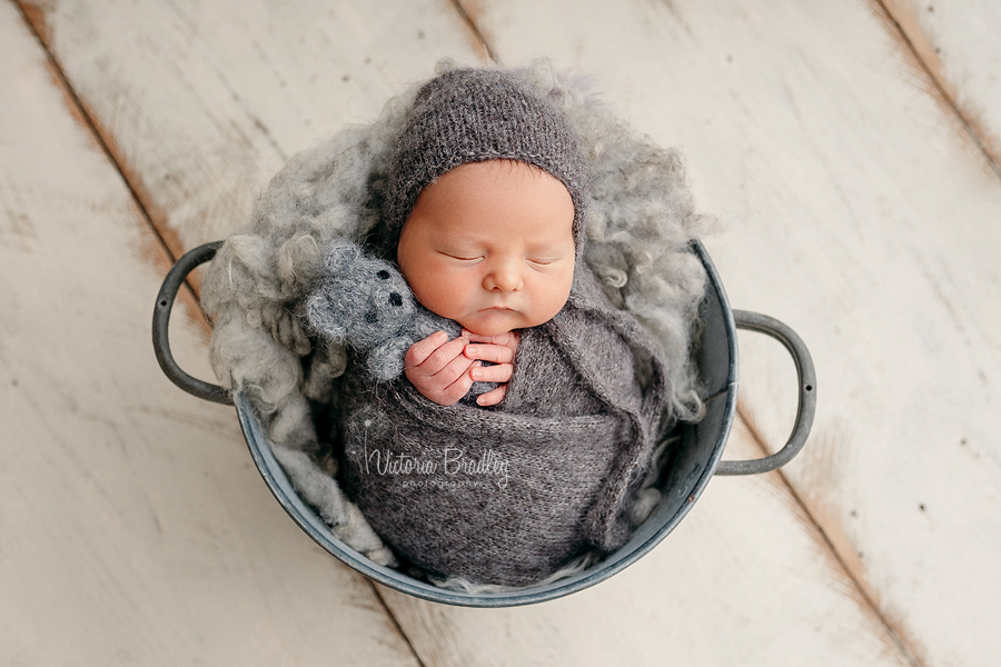 wrapped newborn in grey bucket