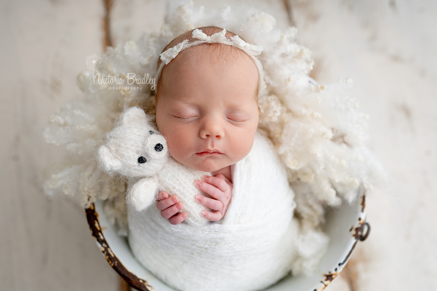 baby girl holding teddy