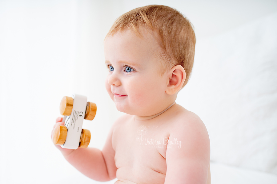 baby with wooden car