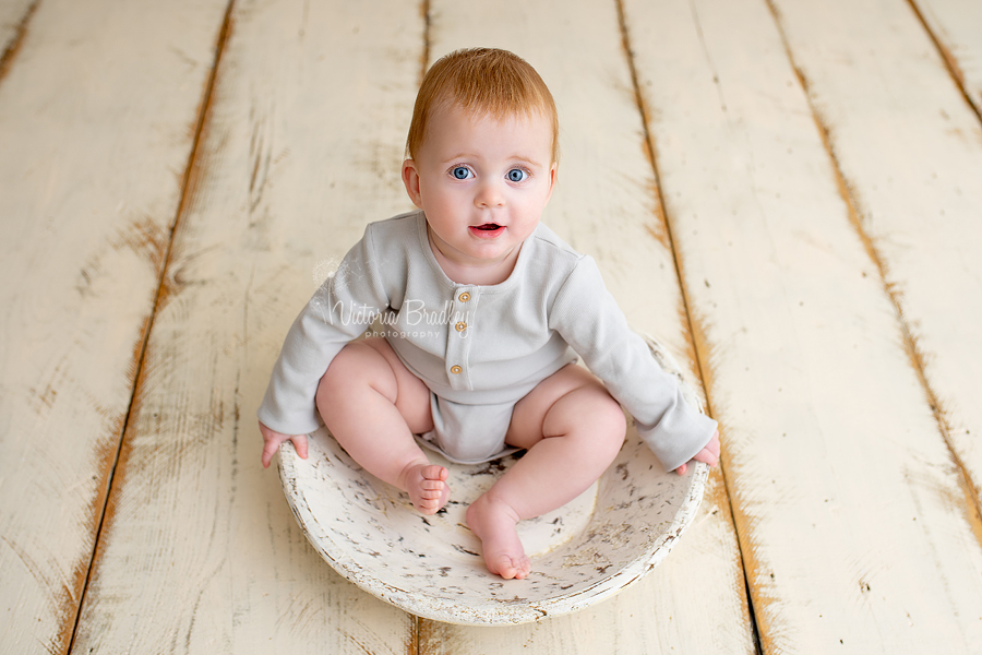 sitter baby in wooden bowl