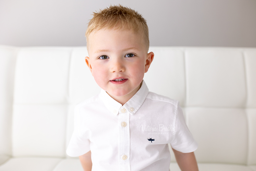 sibling photography, boy on white sofa