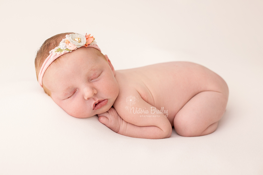 baby on tummy on peach backdrop