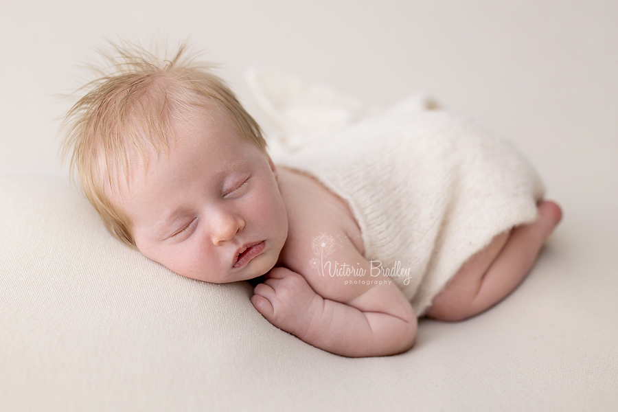 newborn baby boy on cream blanket