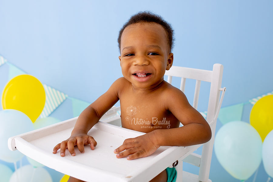 baby boy in high chair cake smash