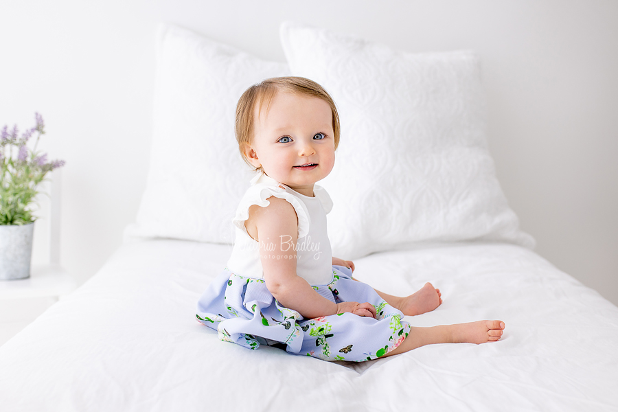 baby girl on white bed set up with lavender 