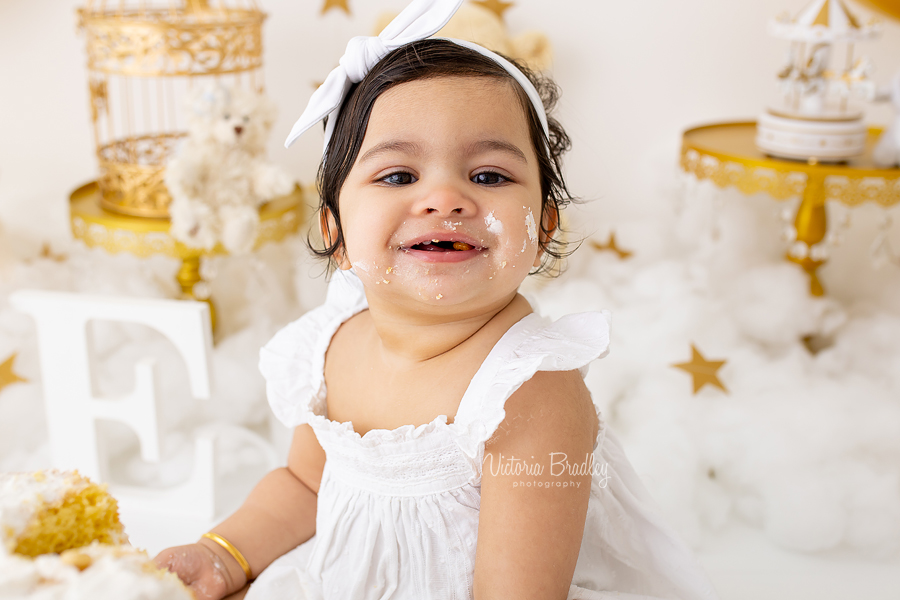 smiling baby girl cake smash gold and white