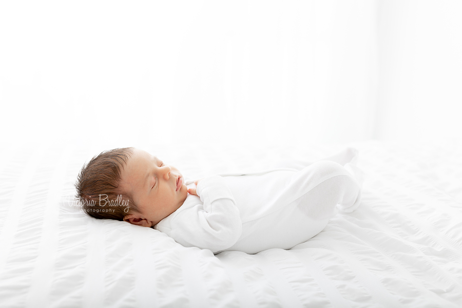 newborn on white bed