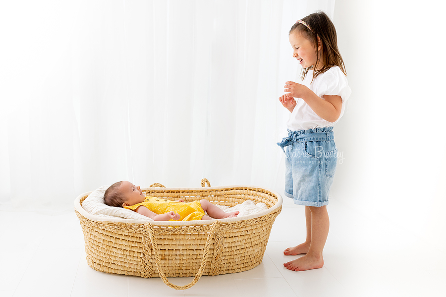 4 year old and newborn in Moses basket