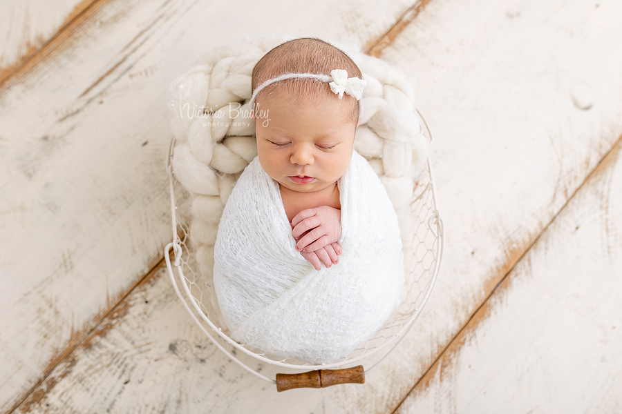 wrapped asleep newborn on basket