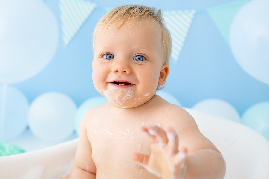 baby boy waving at camera