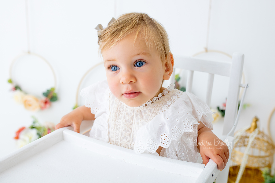 floral cake smash baby in white high chair