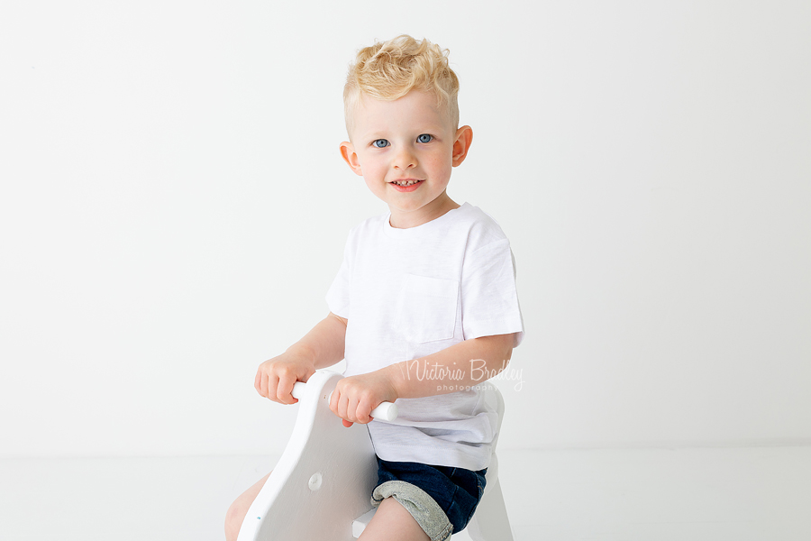 close up of 2 year old boy on rocking horse