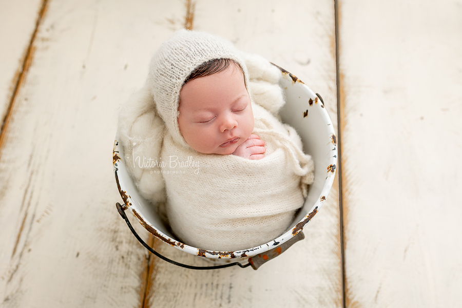 wrapped newborn in cream bucket