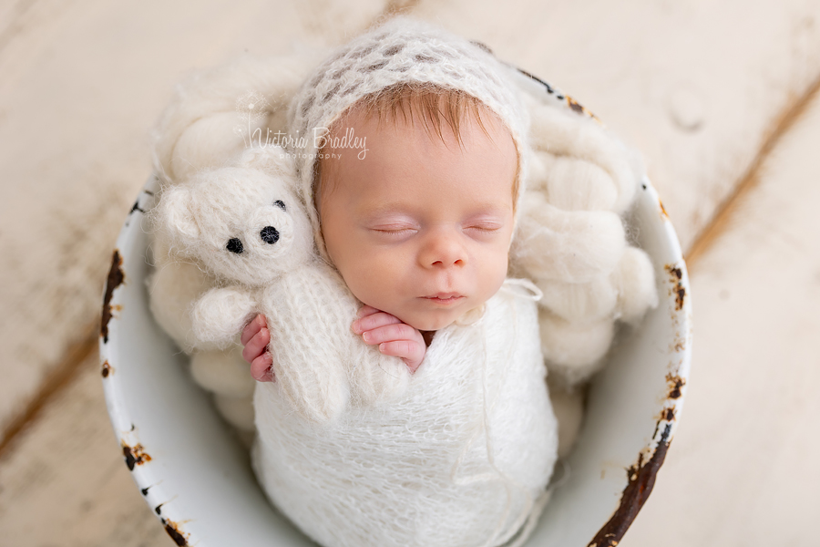 wrapped newborn with small teddy