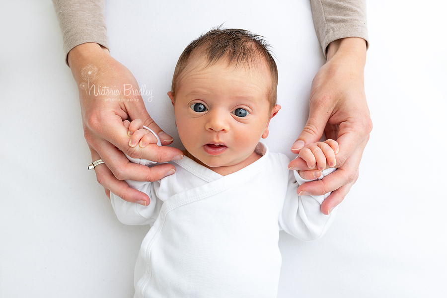 newborn girl holding Mummy's hands