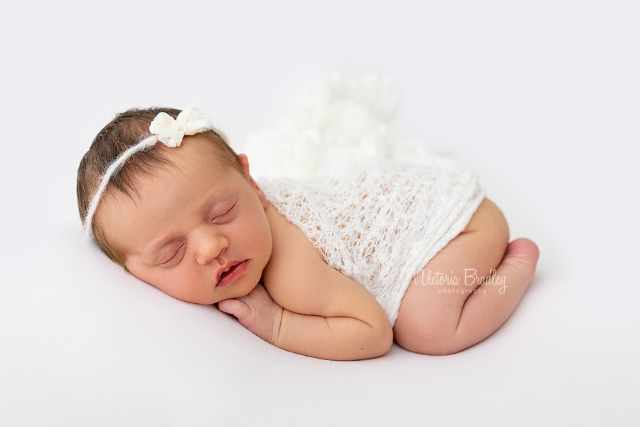 sleepy newborn on pale pink