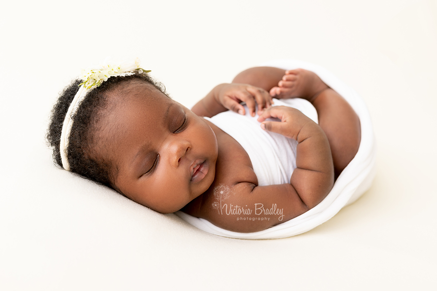 egg wrap pose newborn on yellow