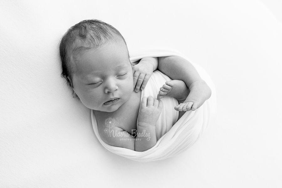 black and white image of wrapped newborn 