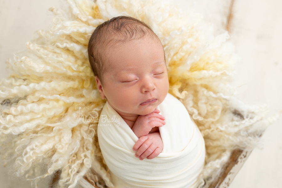 wrapped newborn baby image on yellow