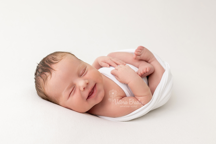 smiling wrapped newborn