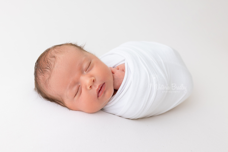 wrapped newborn baby image on white