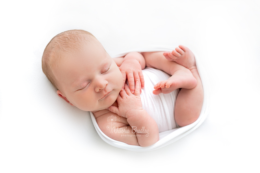 wrapped newborn on white backdrop