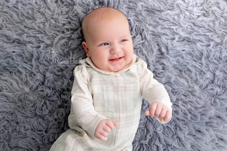 smiley baby on grey rug