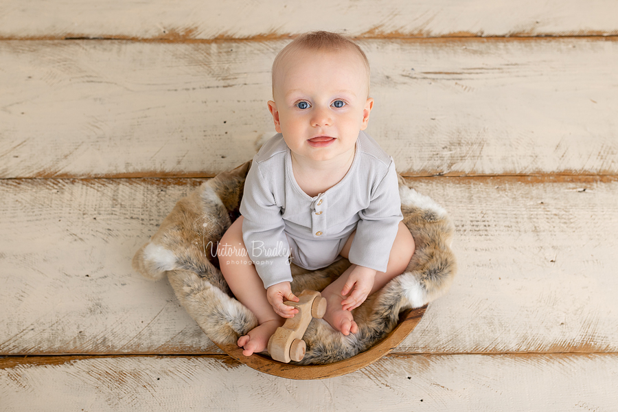 baby sat in wooden bowl