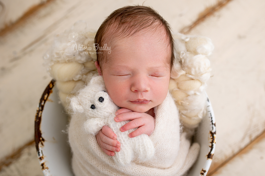 newborn holding teddy