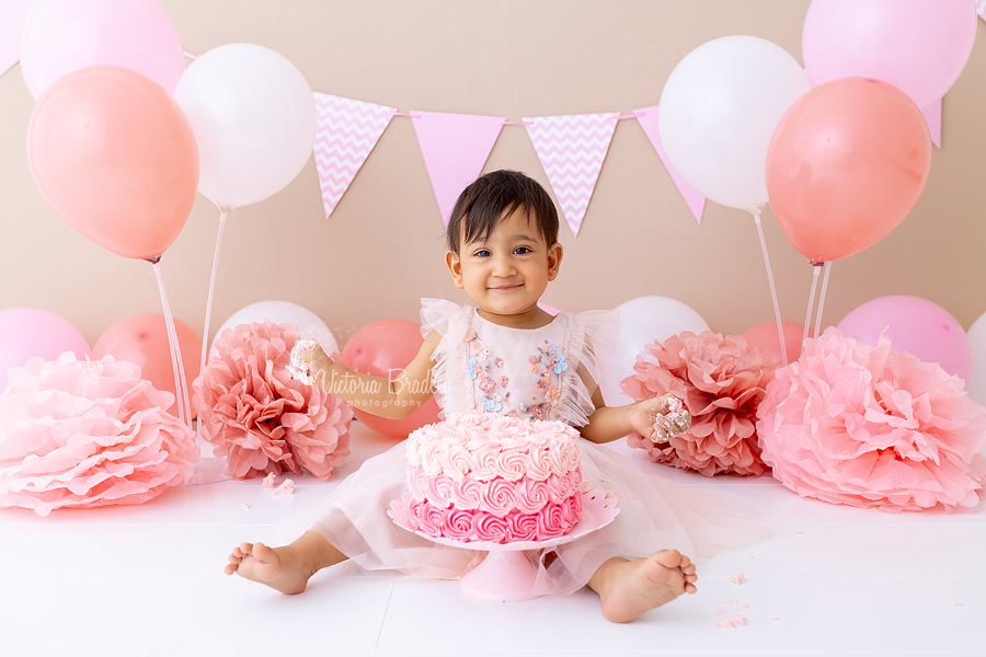 smiling baby girl with pink cake