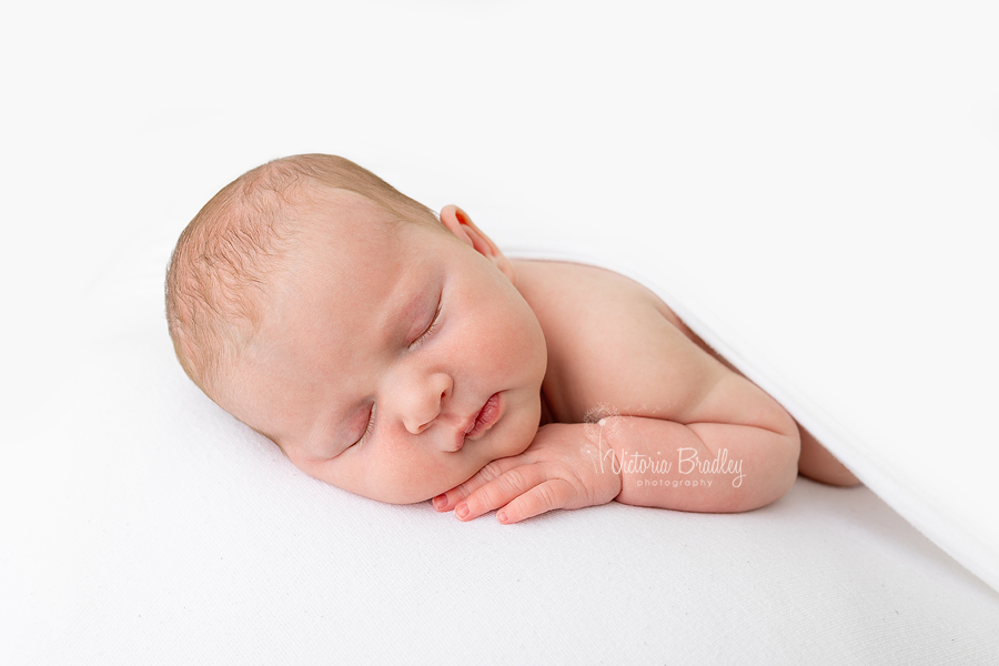 white backdrop, sleepy newborn baby girl