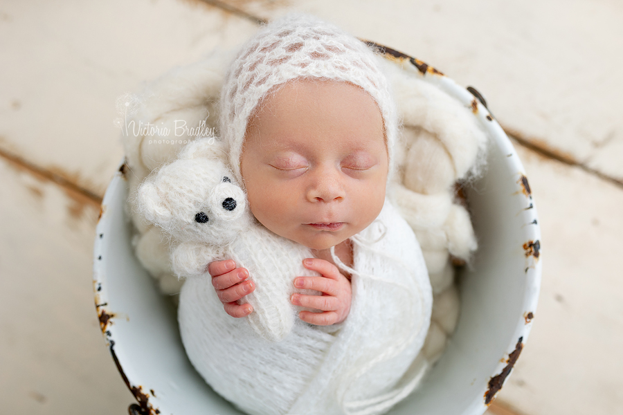 wrapped newborn in white with teddy