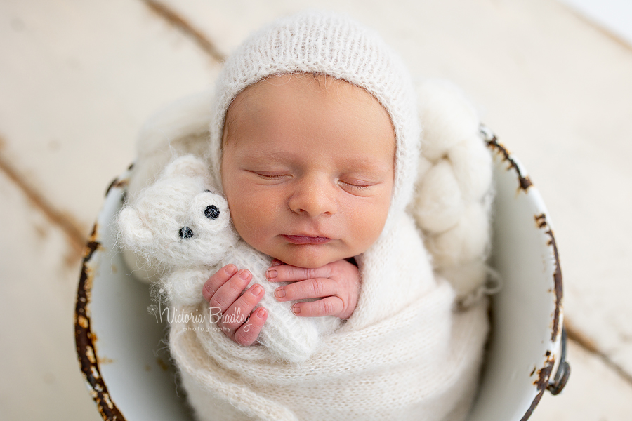 wrapped newborn with small teddy