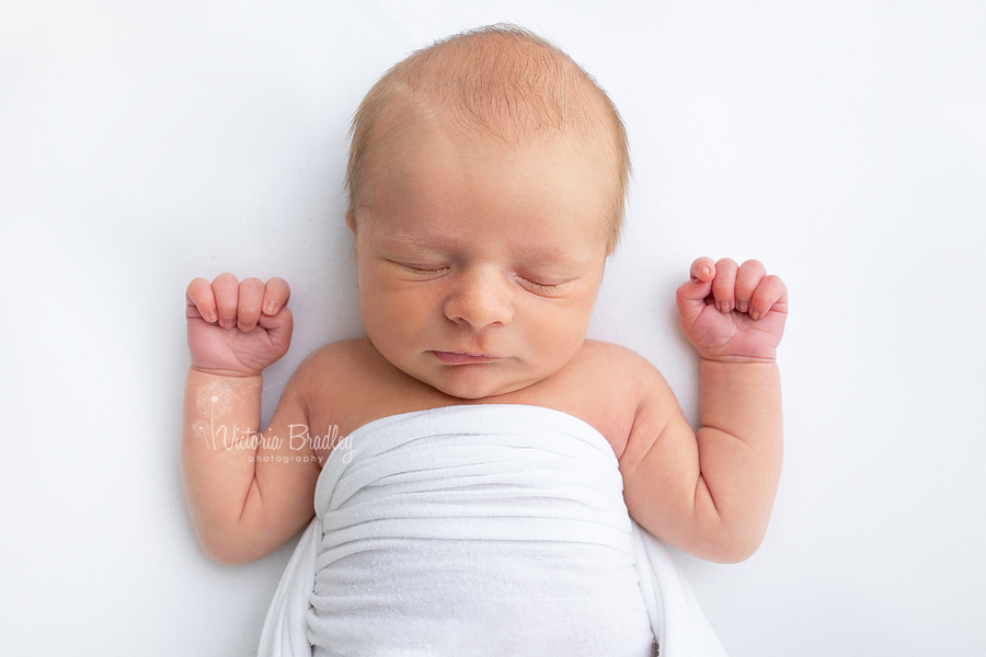 sleepy newborn on white