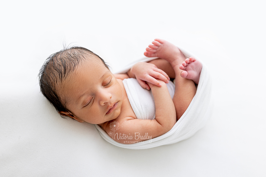 wrapped newborn on white