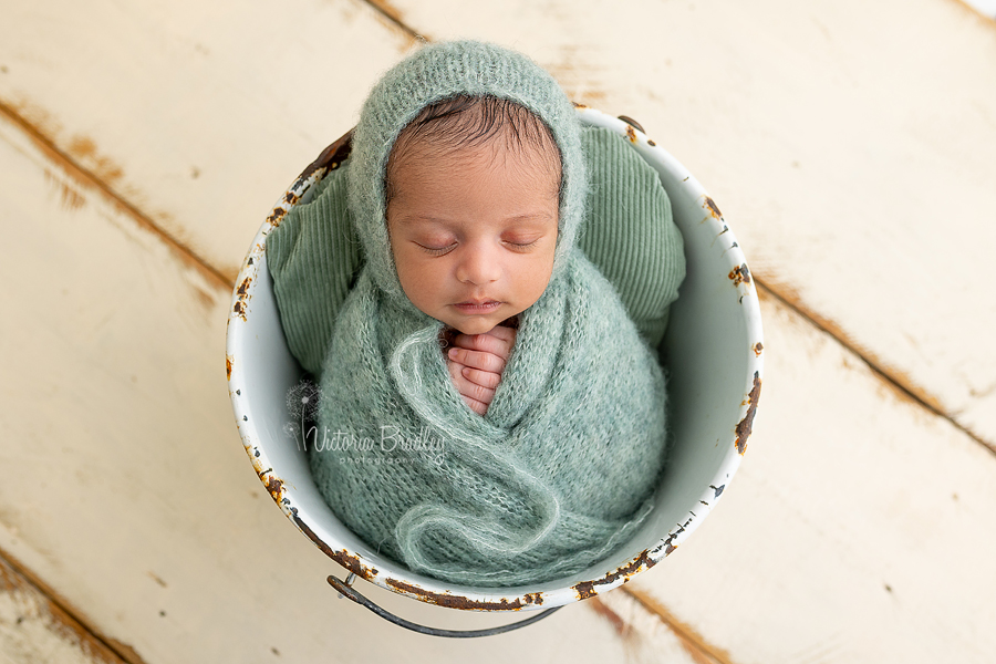 wrapped newborn baby boy in sage green