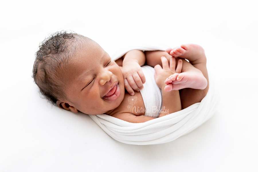 smiling wrapped newborn