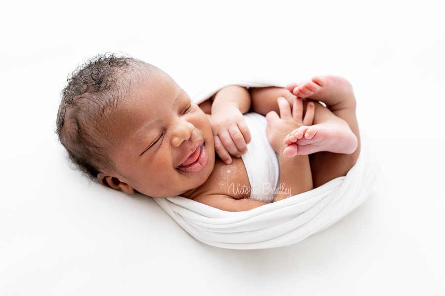 smiling asleep newborn baby in egg wrap