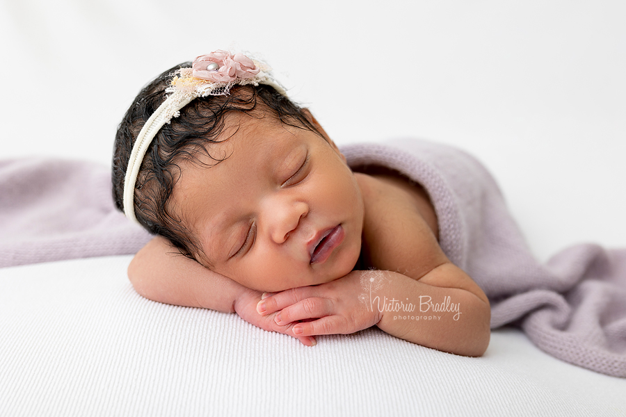 chin on hands newborn baby pose