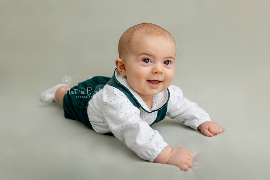 sitter on tummy on sage green blanket