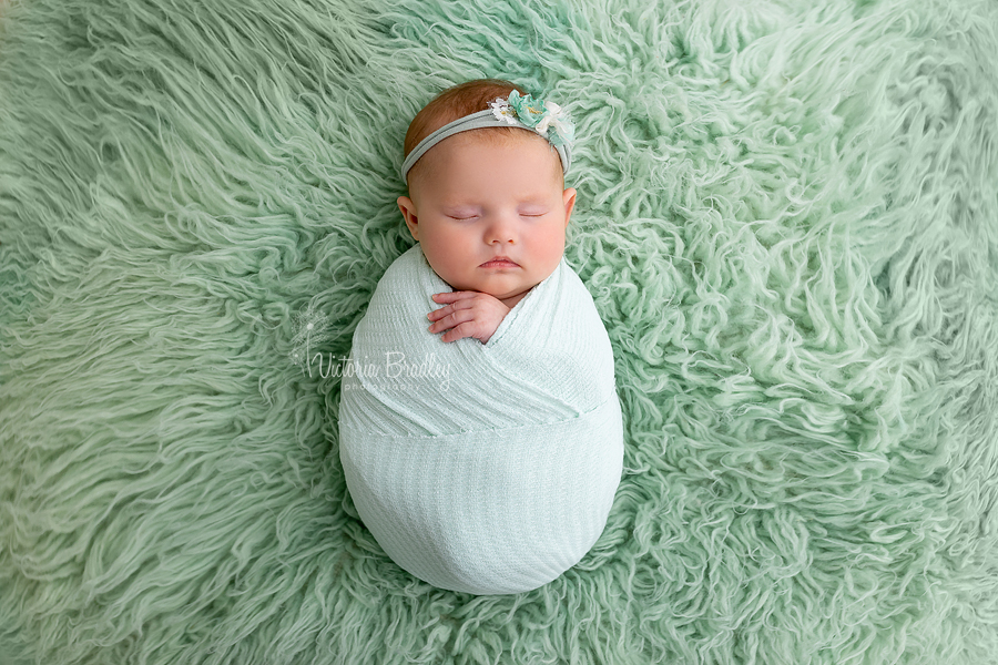 wrapped newborn sleepy on mint green
