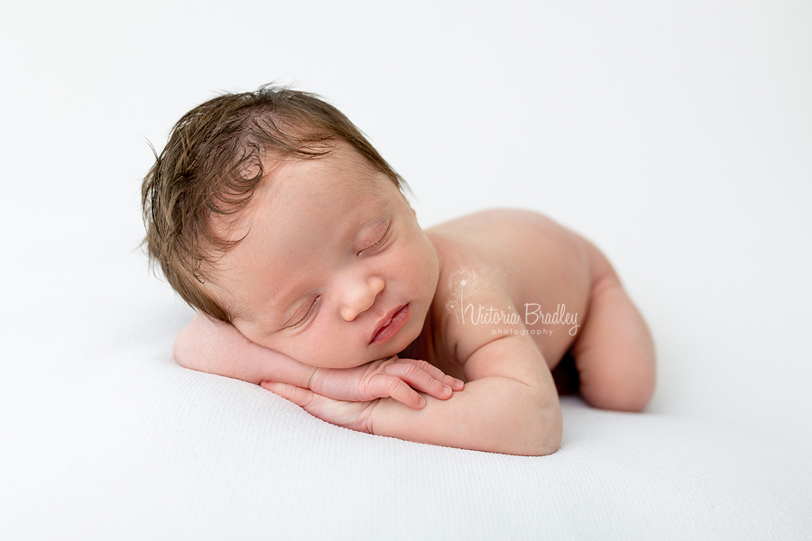 sleepy newborn, chin on hands pose
