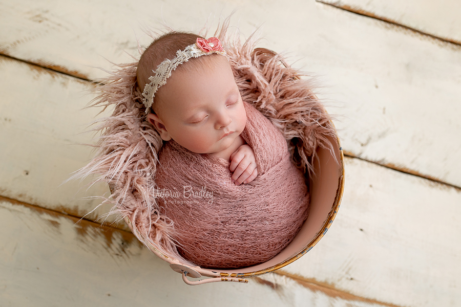 wrapped newborn in pink bucket