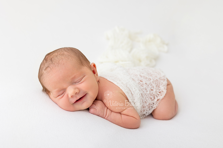 smiling newborn on tummy asleep photography 
