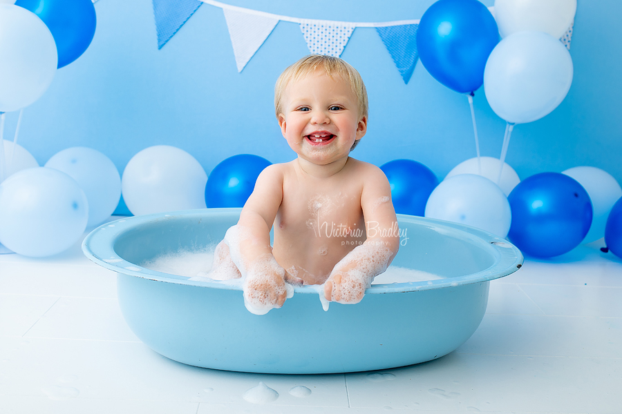 smiley baby boy in blue bath tub photography