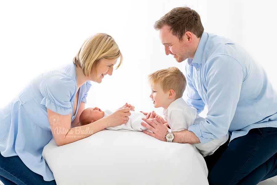family with newborn on white