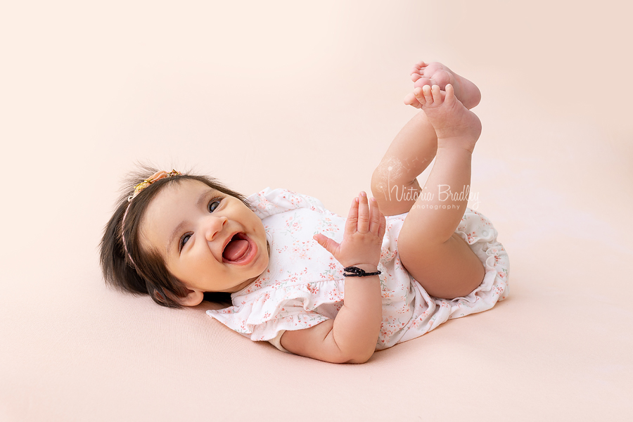 happy baby on peach backdrop